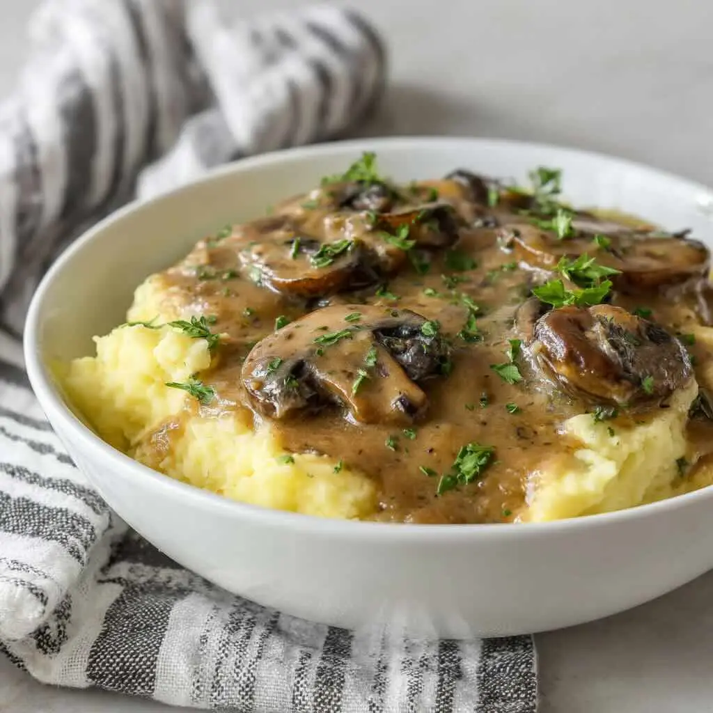 Mashed potatoes with vegan mushroom gravy in white bowl
