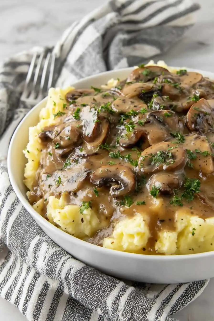 Vegan mushroom gravy over mashed potatoes with parsley garnish